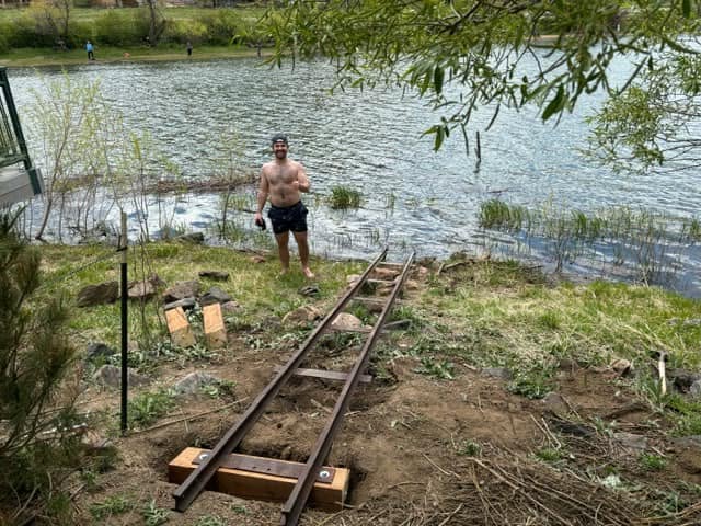 A volunteer setting the staff gauge track into the shoreline