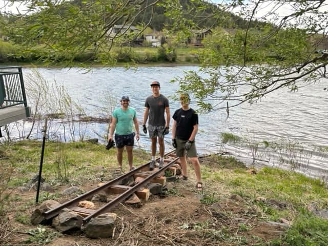 Volunteers standing with the staff gauge during installation