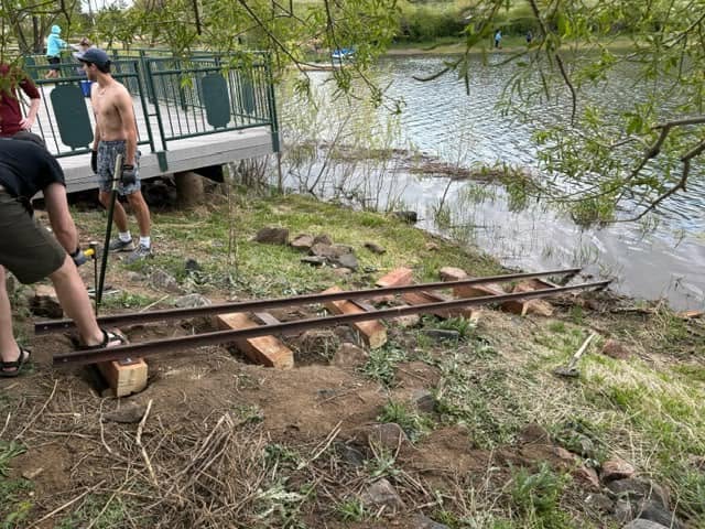 A volunteer leveling the staff gauge track along the bank
