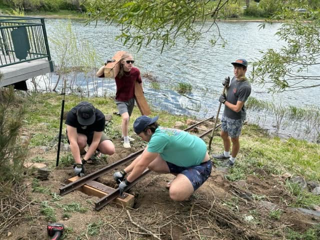 Volunteers working together to install the staff gauge