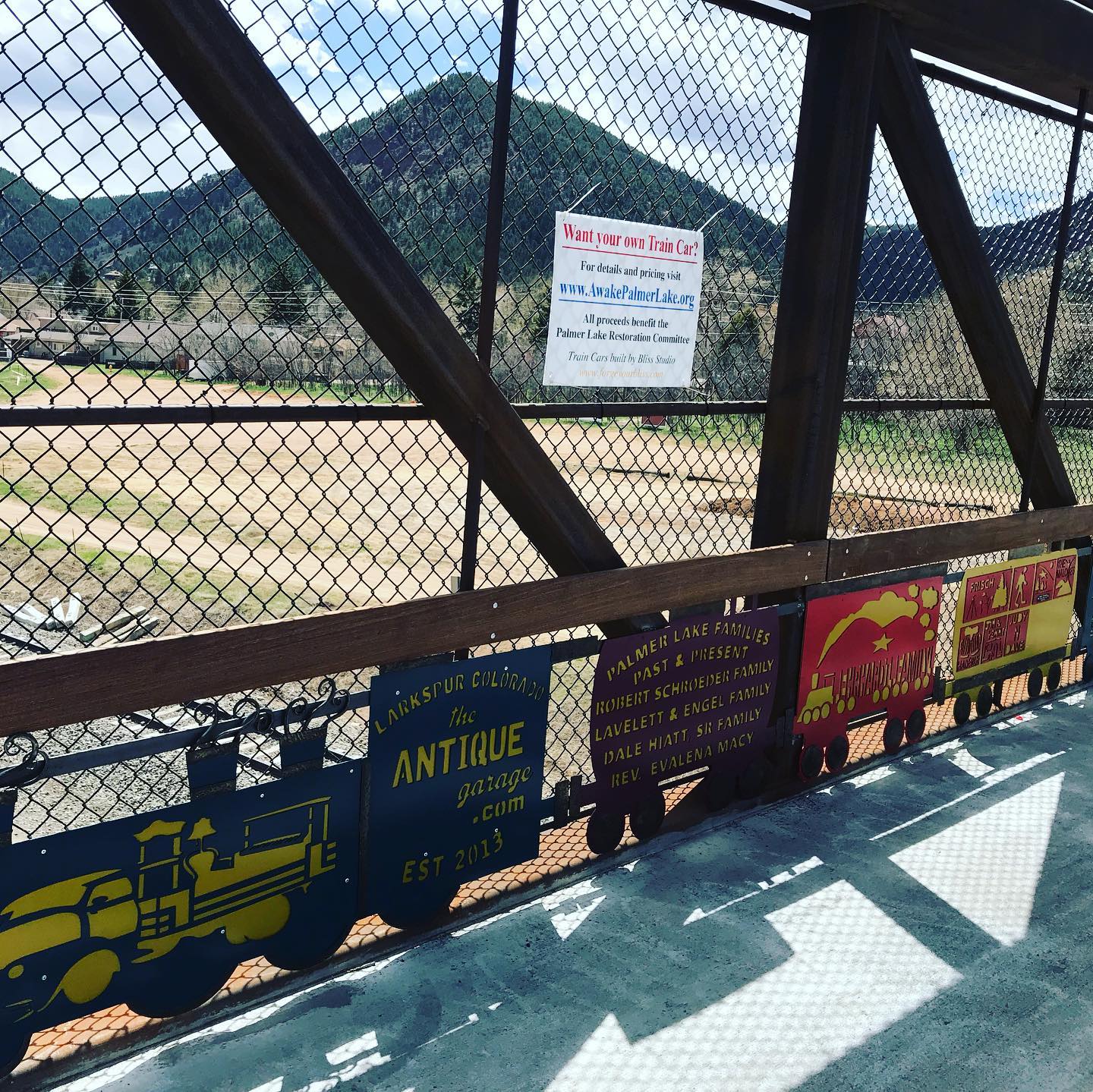 A lineup of sponsored train car panels along the pedestrian bridge railing